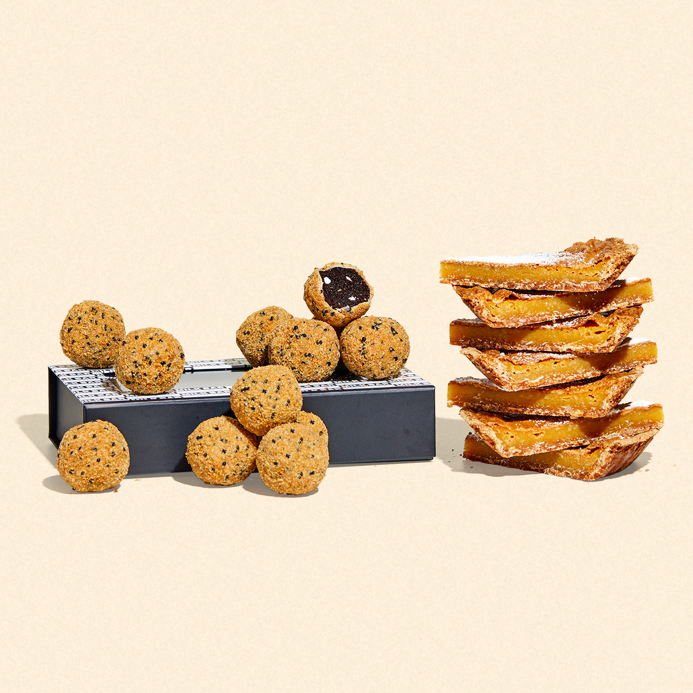 A giftable branded dozen box of s'mores cake truffles beside a stack of milk bar pie slices.