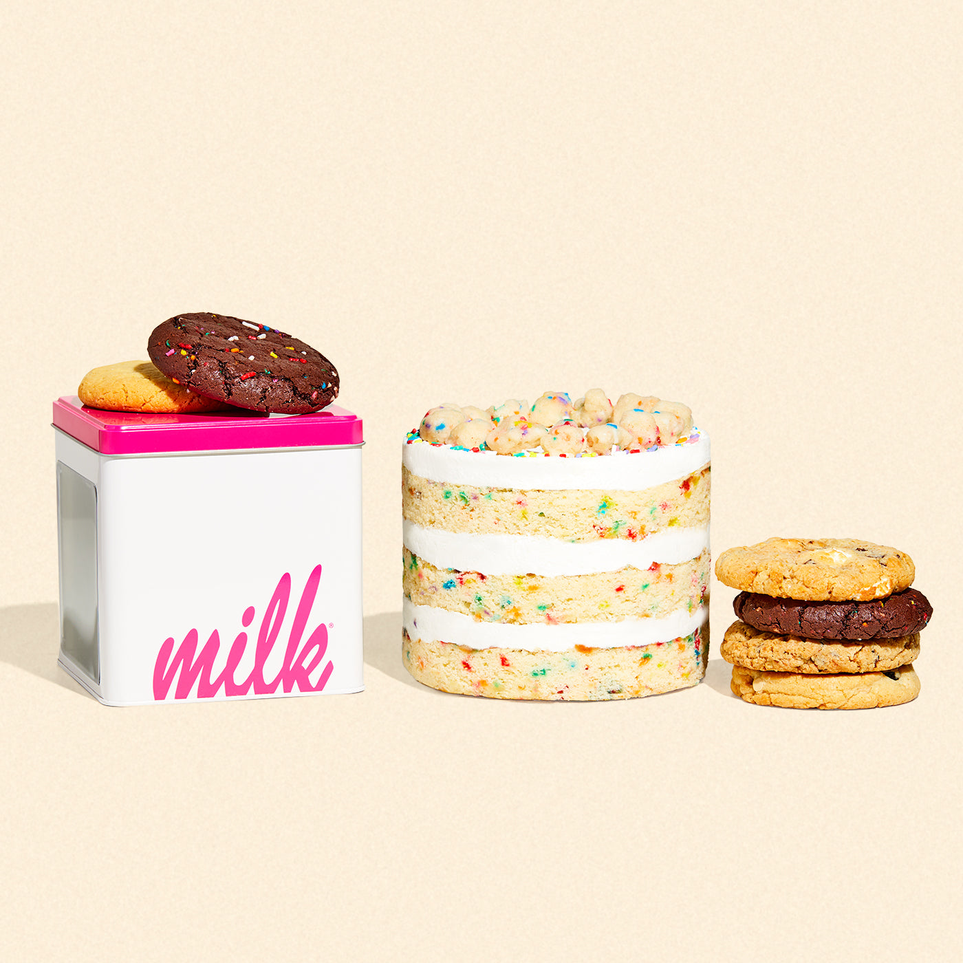 A 6 inch birthday cake beside an assorted cookie tin