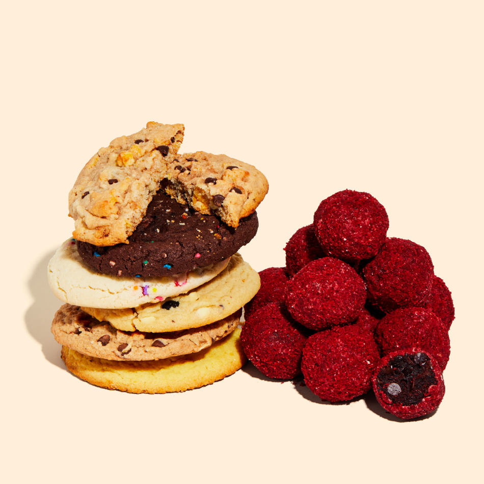 A stack of assorted cookies sitting beside a pile of Red Velvet Cheesecake Truffles.